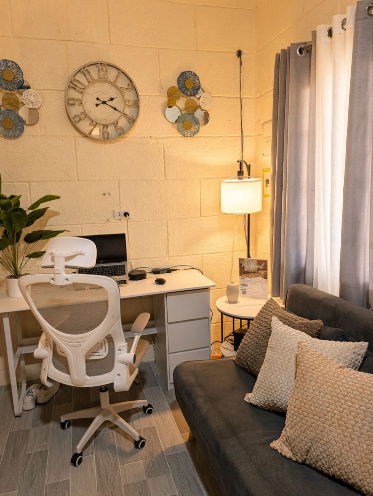 Living room with a desk and office chair, grey sofa and floor lamp